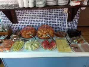 um buffet com pratos de comida no balcão em Pousada Delle Rose em Porto de Galinhas