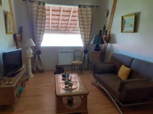 a living room with a couch and a table at La Guette in Cercy-la-Tour