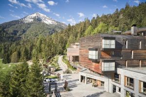 um edifício com uma montanha ao fundo em Das Kronthaler - Adults only em Achenkirch