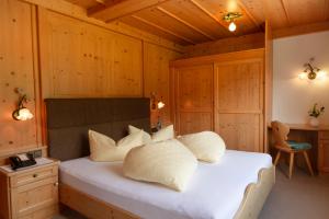 Schlafzimmer mit einem weißen Bett und Holzwänden in der Unterkunft Metzgerwirt in Hippach