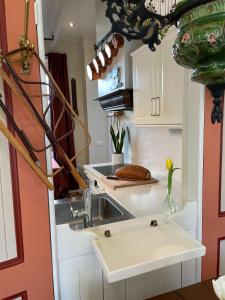 a kitchen with a sink and white cabinets at BnB 't Ambacht - Boutique Hotel in Hendrik-Ido-Ambacht +23 photos