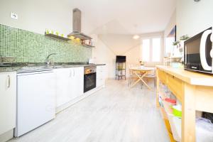 a kitchen with white cabinets and a counter top at Luanco 11 Apartamento ,centro de Gijón in Gijón