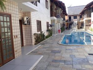 a house with a swimming pool in a courtyard at Flat em Juquehy, 2 quartos, piscina e ar condicionado in São Sebastião