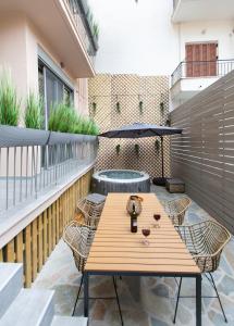 a patio with a wooden table and chairs on a balcony at Lepanto Luxury Apartments GF in Nafpaktos