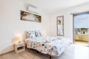 een slaapkamer met een bed en uitzicht op de oceaan bij Appartement Chaleureux et Lumineux Proche Mer in Albufeira