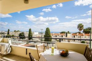 een balkon met een tafel en uitzicht op de stad bij Appartement Chaleureux et Lumineux Proche Mer in Albufeira