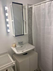 a white bathroom with a sink and a mirror at Holiday house near forrest, harbor and beach in Vedbæk