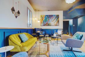 a living room with a yellow couch and chairs at Alex Hotel & Spa in Marseille