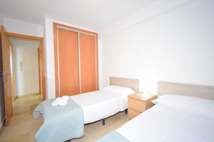pokój hotelowy z dwoma łóżkami i stołem w obiekcie Carolina - Fincas Arena w mieście Benidorm +28 zdjęć