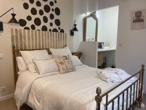 een bed met witte lakens en kussens in een slaapkamer bij Le Patio Combes de Mons in Royan