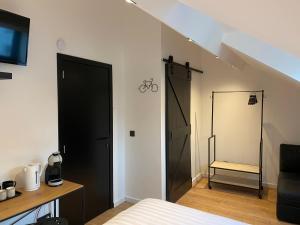 um quarto com uma cama e uma porta preta em Rouleur Houffalize em Houffalize