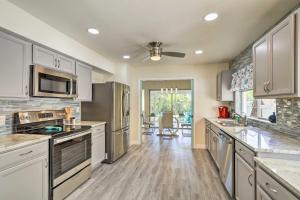 a kitchen with stainless steel appliances and white cabinets at Tropical Waterfront Home Central Location! in Clearwater Beach
