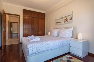 a bedroom with a bed with a wooden cabinet at Casa Miha in Sintra