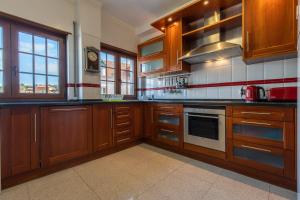 a kitchen with wooden cabinets and a stove top oven at Casa Miha in Sintra