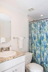 a bathroom with a toilet and a shower curtain at Beach Living at Island Pine Villas (BLJ) in George Town
