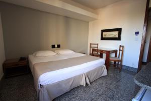 um quarto com uma cama, uma mesa e cadeiras em Savassi Hotel em Belo Horizonte