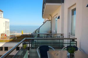 a balcony with a table and chairs and the ocean at Kaiserhof Kaiserhof 205 in Wangerooge