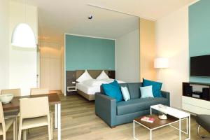 uma sala de estar com um sofá azul e uma cama em Aparthotel Anna Düne Aparthotel Anna Düne 0-05 em Wangerooge