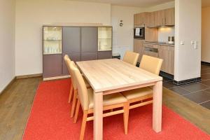 a dining room table with chairs and a kitchen at Resort Deichgraf Resort Deichgraf 31-02 in Wremen