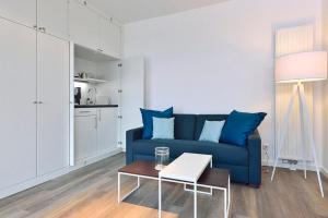 a living room with a blue couch and a table at Aparthotel Anna Düne Aparthotel Anna Düne 2-40 in Wangerooge