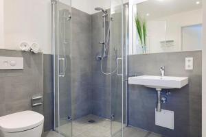 a bathroom with a shower and a toilet and a sink at Aparthotel Anna Düne Aparthotel Anna Düne 2-40 in Wangerooge