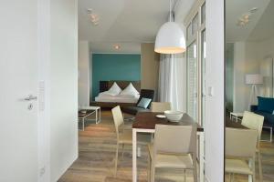 a dining room and living room with a table and chairs at Aparthotel Anna Düne Aparthotel Anna Düne 2-40 in Wangerooge +2 photos