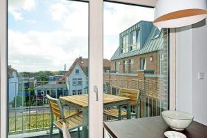 a balcony with a table and chairs and a window at Aparthotel Anna Düne Aparthotel Anna Düne 2-40 in Wangerooge