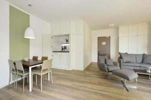 a living room with a table and chairs and a kitchen at Aparthotel Anna Düne Aparthotel Anna Düne 2-39 in Wangerooge