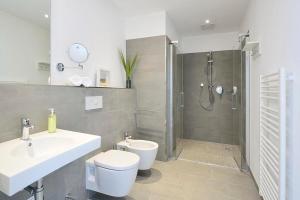a bathroom with a sink and a toilet and a shower at Aparthotel Anna Düne Aparthotel Anna Düne 2-39 in Wangerooge +8 photos