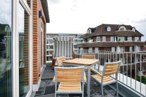 a table and chairs on the balcony of a building at Aparthotel Anna Düne Aparthotel Anna Düne 2-39 in Wangerooge