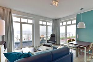 ヴァンガーオーゲにあるAparthotel Anna Düne Aparthotel Anna Düne 1-24の海の景色を望むリビングルーム(青いソファ付)