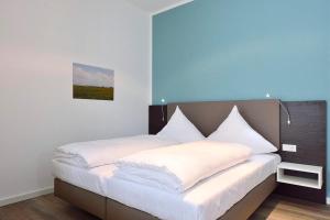a bedroom with a large bed with white sheets at Aparthotel Anna Düne Aparthotel Anna Düne 0-07 in Wangerooge