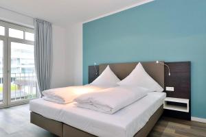 ヴァンガーオーゲにあるAparthotel Anna Düne Aparthotel Anna Düne 1-24のベッドルーム(白い枕の大型ベッド1台付)