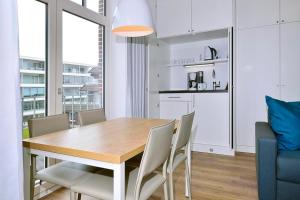a kitchen and dining room with a wooden table and chairs at Aparthotel Anna Düne Aparthotel Anna Düne 2-38 in Wangerooge