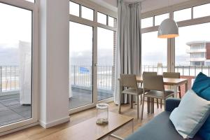 a living room with a blue couch and a table at Aparthotel Anna Düne Aparthotel Anna Düne 2-38 in Wangerooge +4 photos