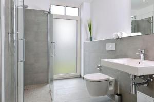 a bathroom with a toilet and a sink and a shower at Aparthotel Anna Düne Aparthotel Anna Düne 2-38 in Wangerooge
