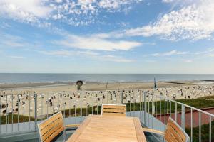 a balcony with a table and chairs and a beach at Aparthotel Anna Düne Aparthotel Anna Düne 2-38 in Wangerooge