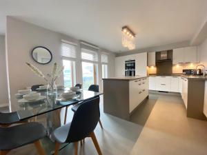 a kitchen and dining room with a glass table and chairs at Bonnie Links in Prestwick