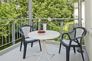 einen Tisch und zwei Stühle auf einem Balkon mit einer Obstschale in der Unterkunft Strand-Park Strand-Park 213 in Heringsdorf