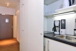 a white kitchen with a sink and a counter top at Aparthotel Anna Düne Aparthotel Anna Düne 1-23 in Wangerooge