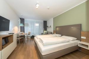 a bedroom with a large white bed and a desk at Apartmentvilla Anna See Apartmentvilla Anna See 1-06 in Langeoog