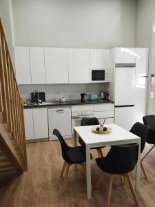 uma cozinha com armários brancos e uma mesa e cadeiras em Apartamento Retiro em Madri