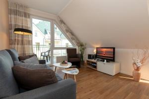 a living room with a couch and a television at Ostseeallee 32b Ostseeallee 32b 2-2 in Kühlungsborn