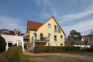 a yellow house with a balcony on top of it at Ostseeallee 32b Ostseeallee 32b 2-2 in Kühlungsborn