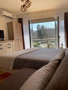 1 Schlafzimmer mit 2 Betten und einem großen Fenster in der Unterkunft Apartman Nice in Vrnjačka Banja