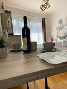 eine Flasche Wein auf einem Holztisch in der Unterkunft Apartman Nice in Vrnjačka Banja