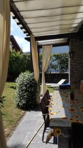eine Terrasse mit einem Tisch und einem Sonnenschirm in der Unterkunft Bed & Breakfast Gli Oleandri in Stresa