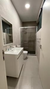 een badkamer met een wastafel, een douche en een toilet bij Duarte Apartments - Lux in Mindelo