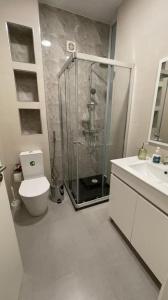 een badkamer met een douche, een toilet en een wastafel bij Duarte Apartments - Lux in Mindelo