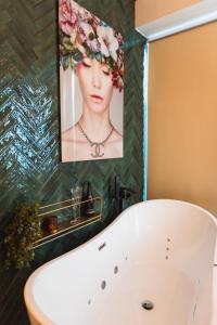 a bath tub in a bathroom with a picture of a woman at FeWo Time Out 2 in Vreden
